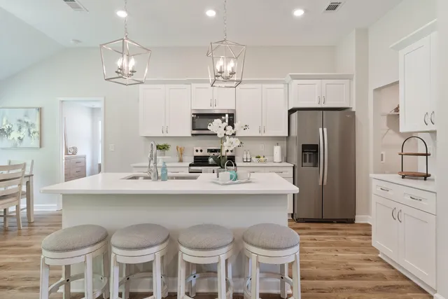 a kitchen with stainless steel appliances a dining table and chairs