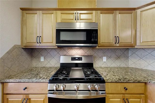 a stove top oven sitting inside of a kitchen