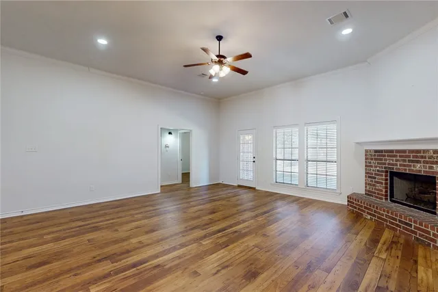 an empty room with windows and fireplace