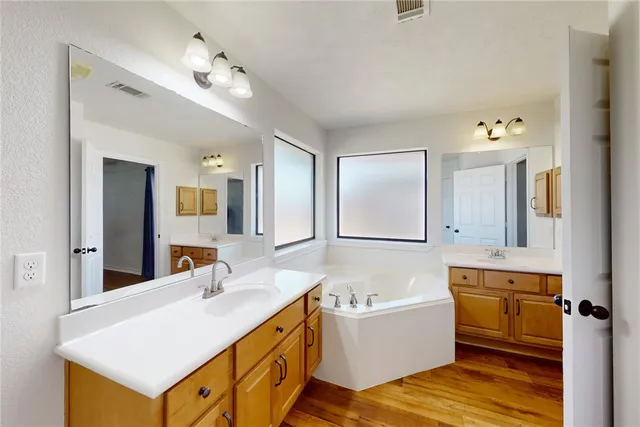 a bathroom with a tub sink and mirror