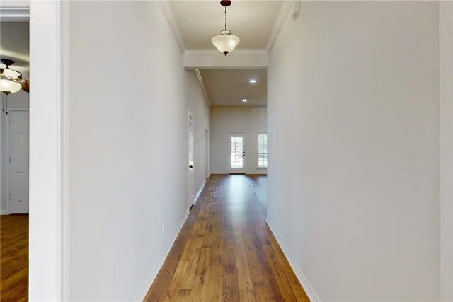 a view of a hallway with wooden floor and staircase