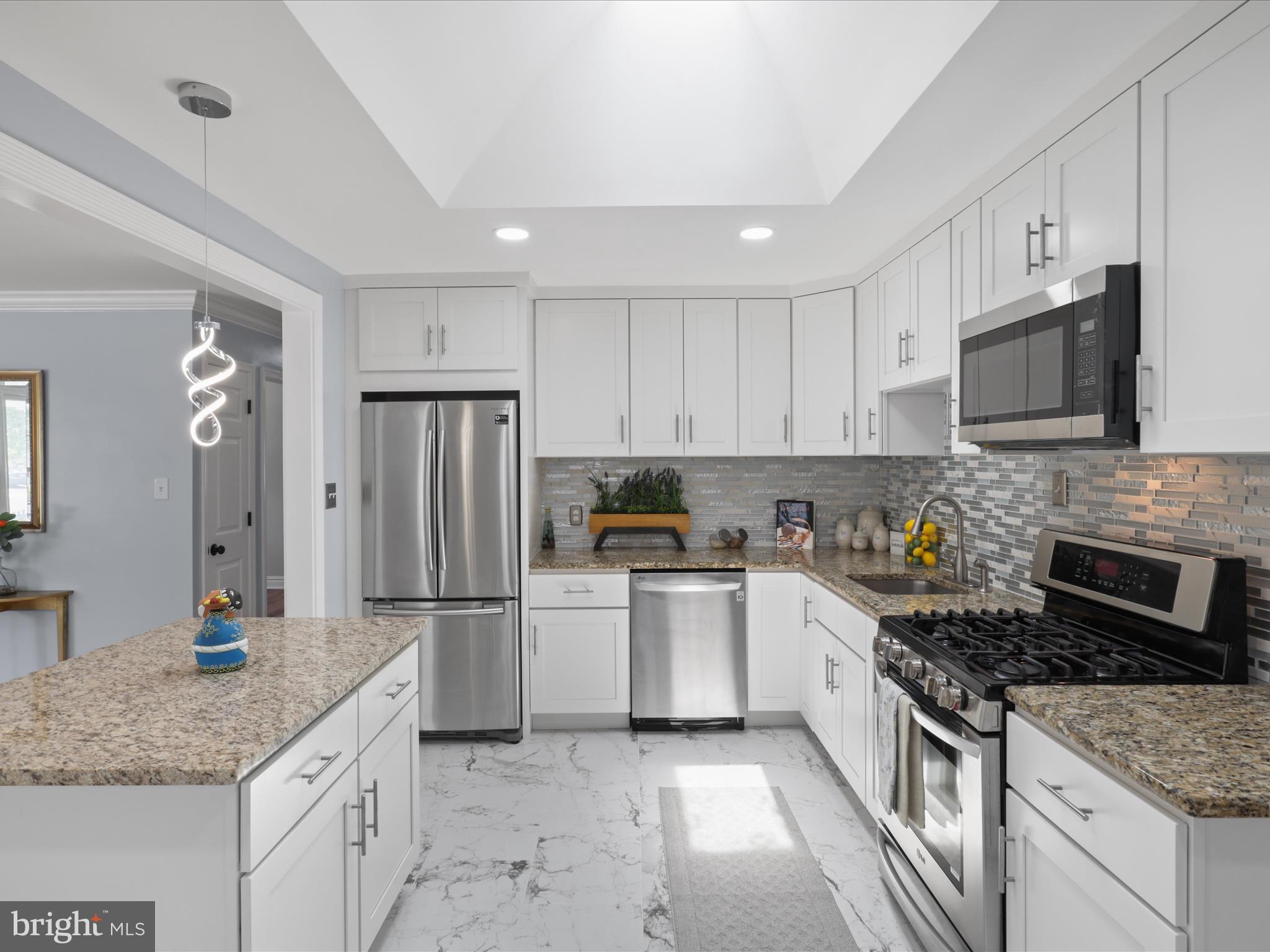 8211 Hocking Place Alexandria, VA 22309 - Photo 12 of 45 a kitchen with stainless steel appliances granite countertop a stove refrigerator sink and microwave