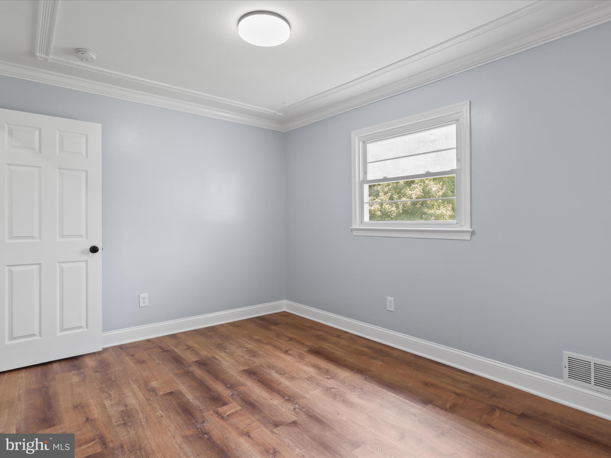 8211 Hocking Place Alexandria, VA 22309 - Photo 26 of 45 a view of an empty room with wooden floor and a window