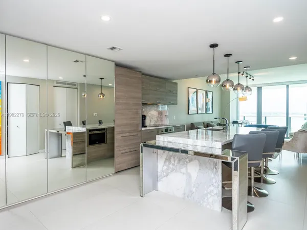 a kitchen with kitchen island granite countertop lots of counter top space and refrigerator