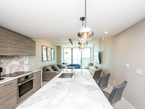 a large kitchen with a large counter top appliances and a window