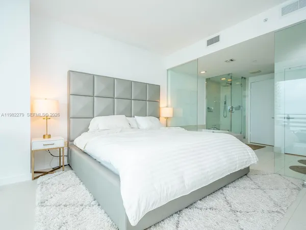 a large bed sitting in a bedroom and a bathroom