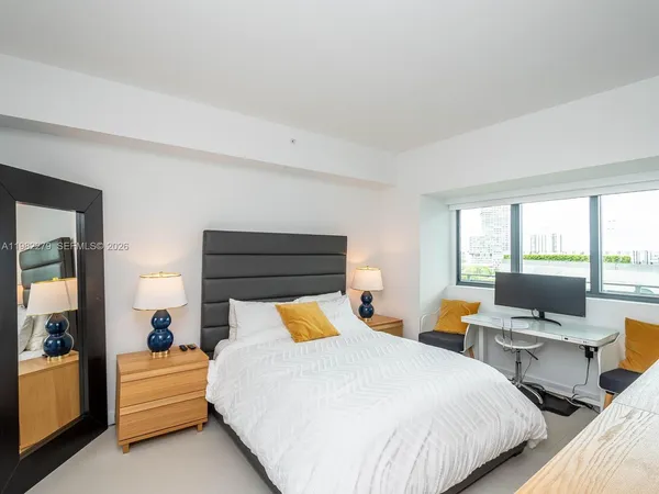 a bedroom with two beds and large window