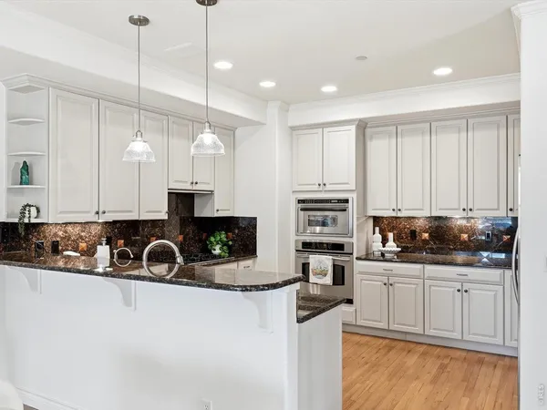 a kitchen with stainless steel appliances granite countertop a sink a stove and a cabinets