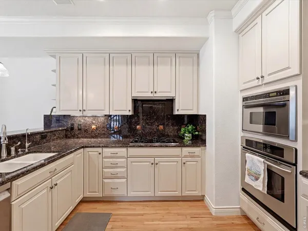 a kitchen with white cabinets and stainless steel appliances
