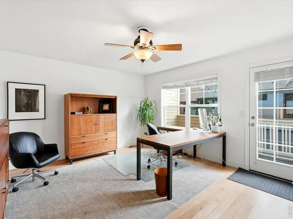 a view of a workspace with furniture and a window