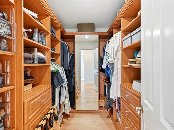 a view of walk in closet with clothes and shoes