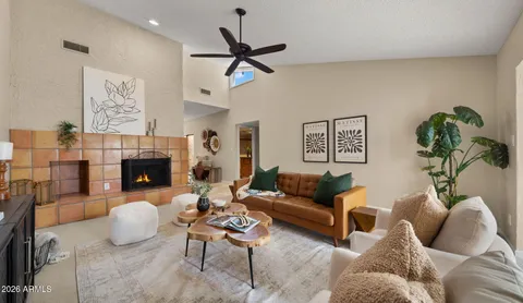 a living room with furniture a fireplace and a large window