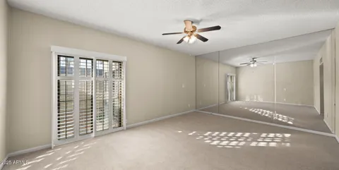 an empty room with closet and windows