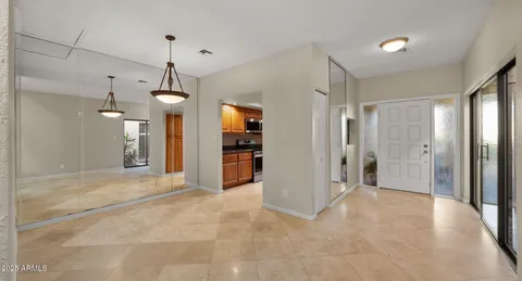a view of a hallway with wooden floor and a living room