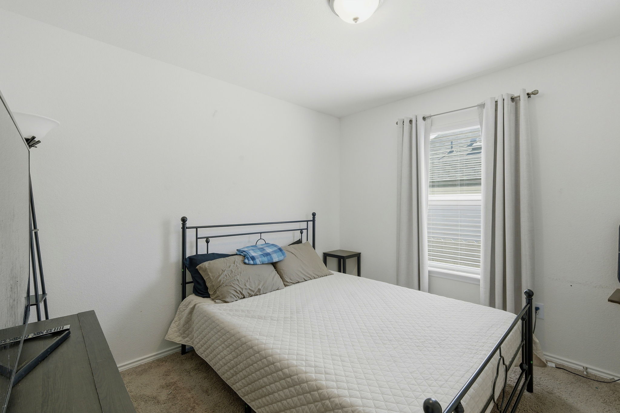 220 Lucky Texan Road Jarrell, TX 76537 - Photo 13 of 19 A quiet bedroom featuring carpeted flooring and a well-lit window, perfect for peaceful rest.