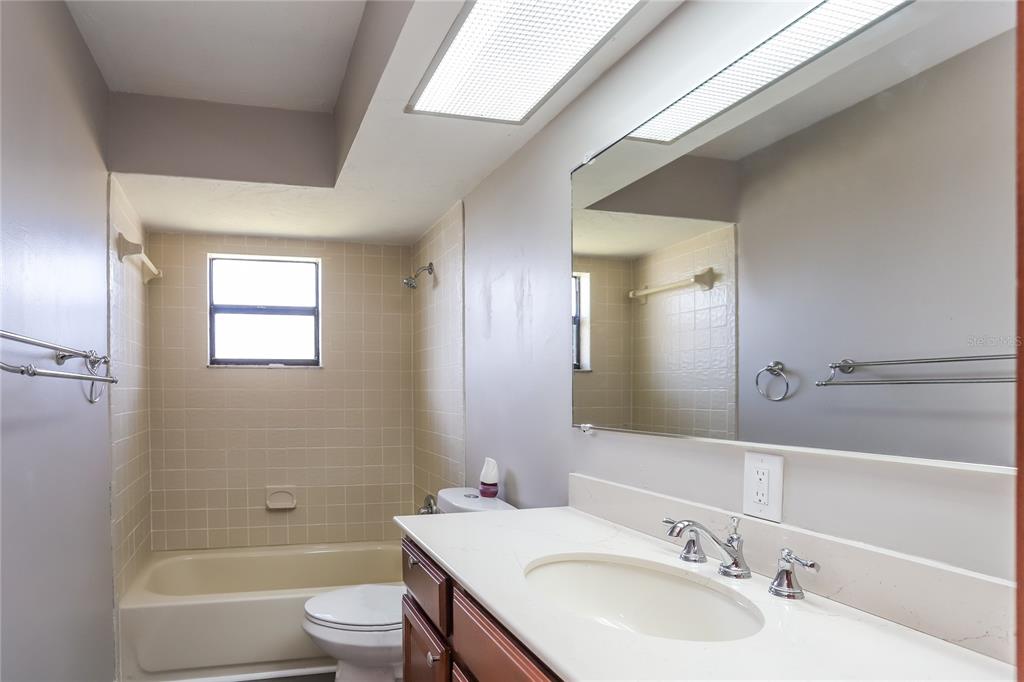 609 Willow Run Lakeland, FL 33813 - Photo 14 of 16 a bathroom with a toilet a sink a mirror and a bathtub