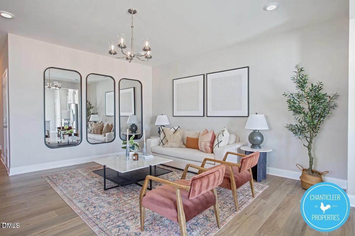 24 Hyacinth Lane, Unit 99 Angier, NC 27501 - Photo 5 of 9 a living room with furniture and a chandelier