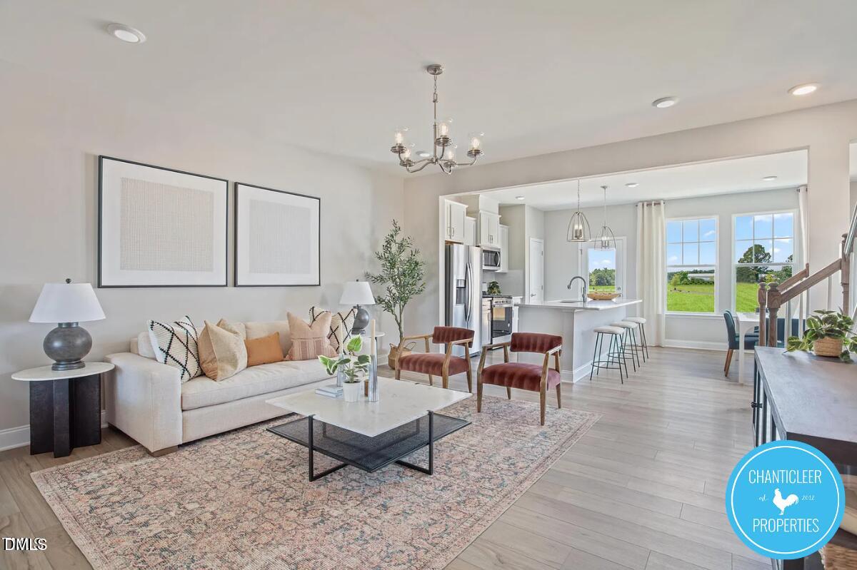 24 Hyacinth Lane, Unit 99 Angier, NC 27501 - Photo 6 of 9 a living room with furniture a chandelier and a rug