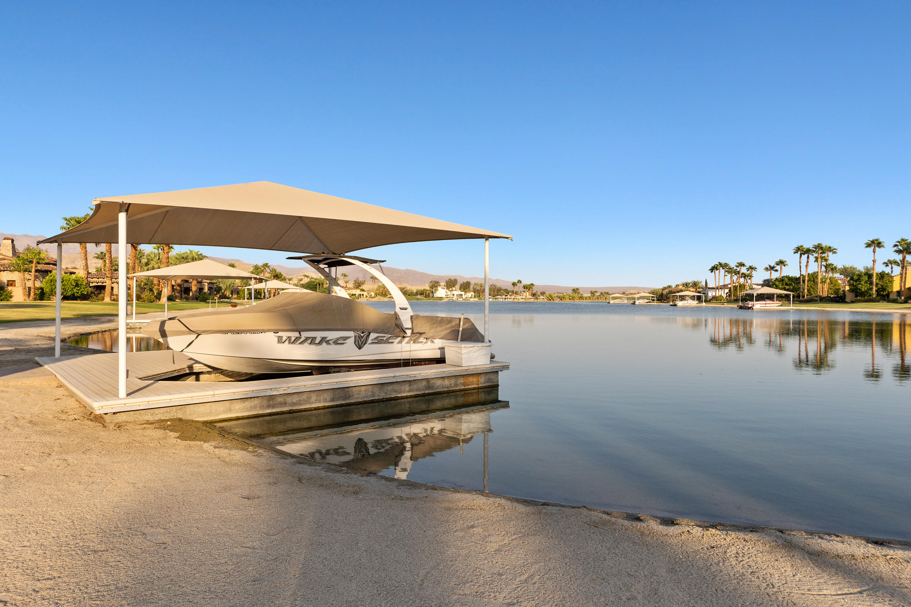 83005 North Shore Drive Indio, CA 92203 - Photo 22 of 40 a view of a lake with couches chairs under an umbrella