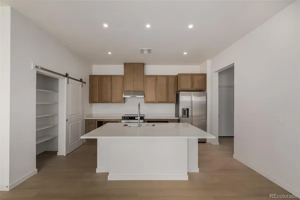 a kitchen with stainless steel appliances a refrigerator sink and microwave