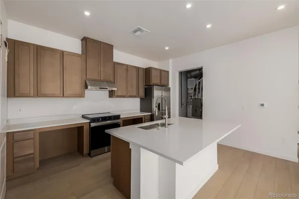 a kitchen with stainless steel appliances granite countertop a sink stove and refrigerator