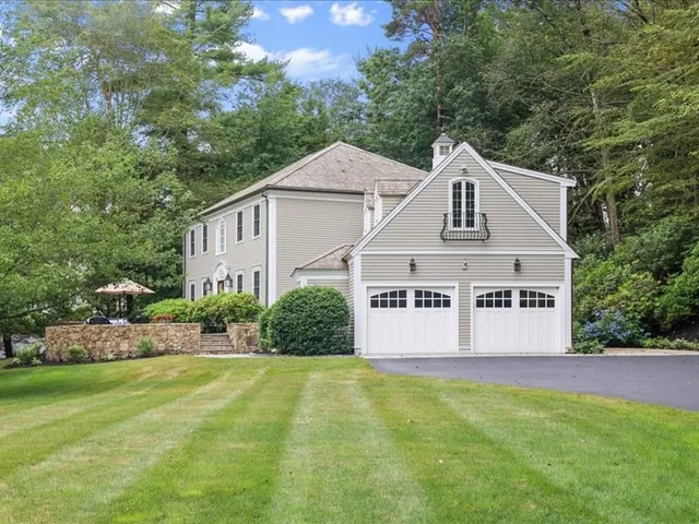 a view of a white house with a large trees