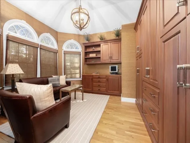 a living room with furniture a chandelier and a large window