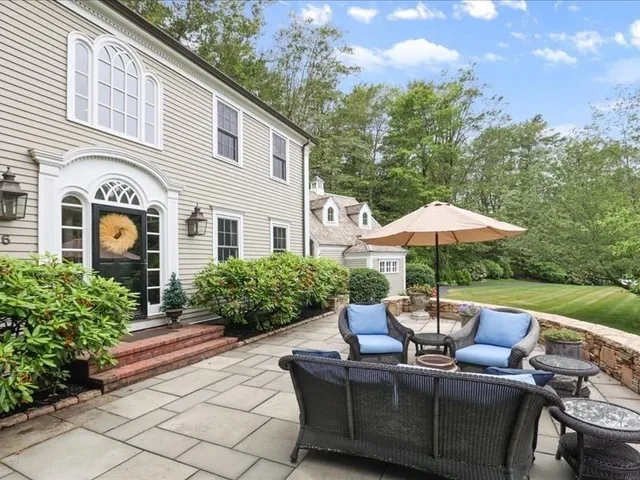 a view of a patio with couches table and chairs under an umbrella