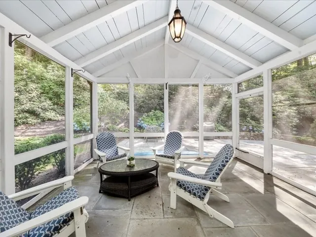 a living room with furniture and floor to ceiling windows