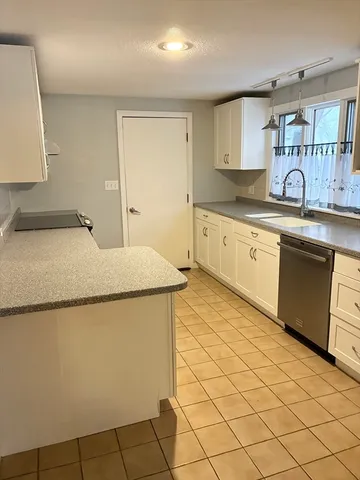 a kitchen with granite countertop sink a stove top oven and cabinets