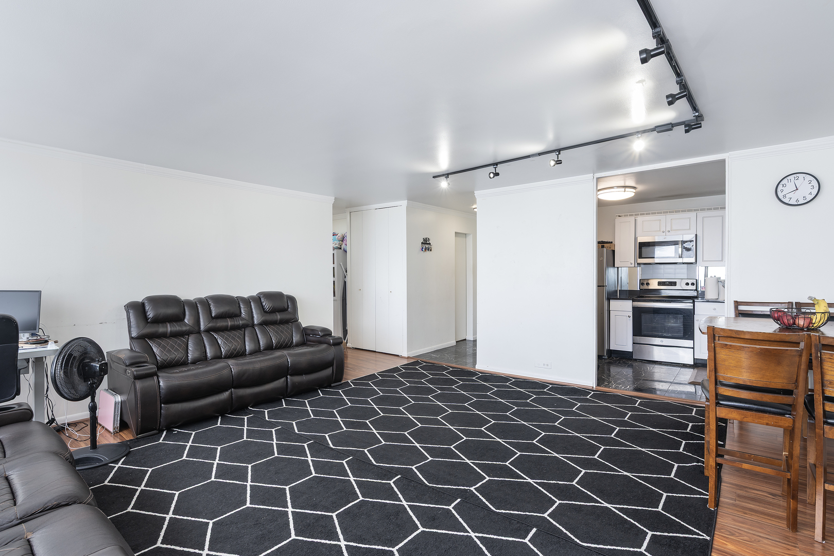 5445 North Sheridan Road, Unit 3210 Chicago, IL 60640 - Photo 7 of 14 a living room with a couch and a bookshelf