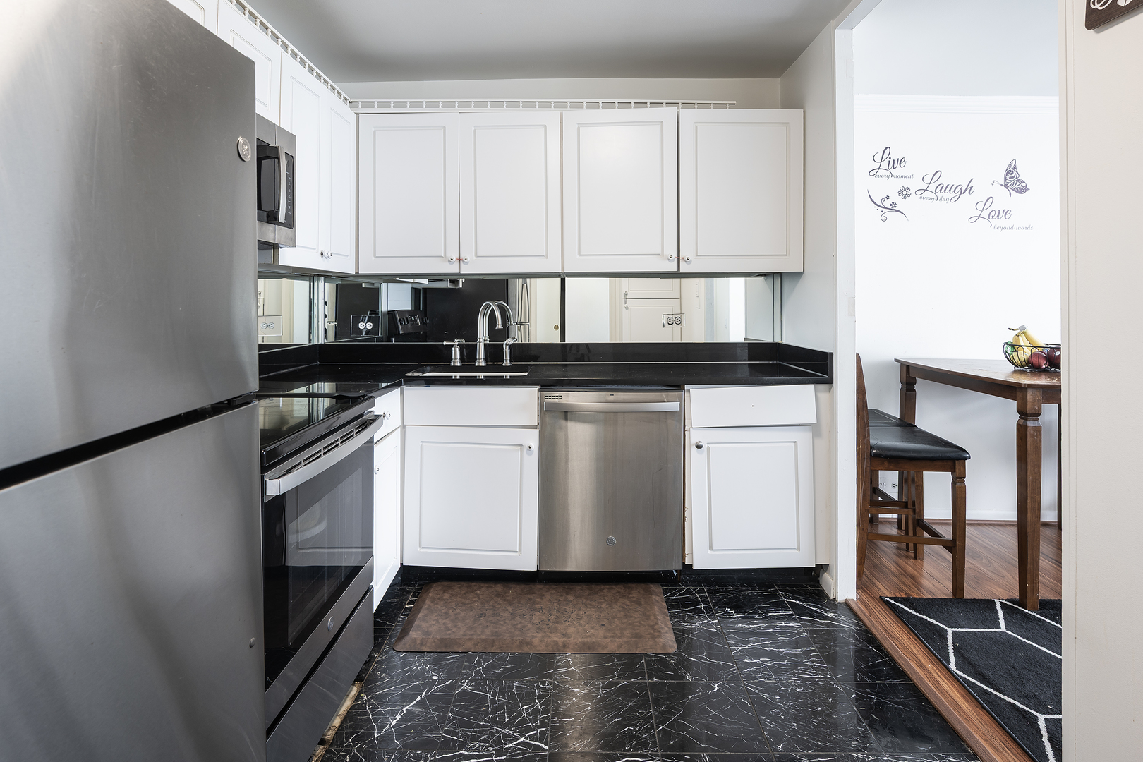 5445 North Sheridan Road, Unit 3210 Chicago, IL 60640 - Photo 9 of 14 a kitchen with stainless steel appliances a stove a microwave and a refrigerator