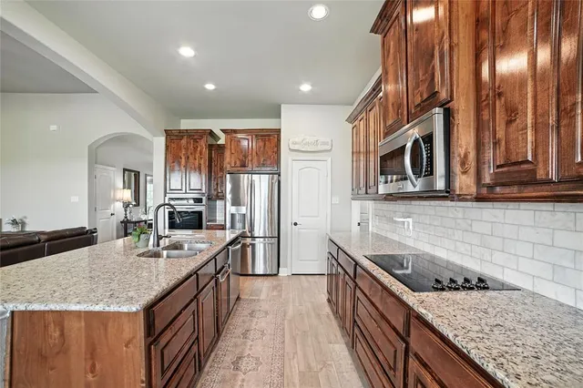 a kitchen with stainless steel appliances granite countertop a sink stove and refrigerator