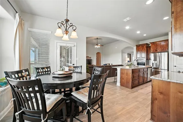 a dining room with wooden furniture a chandelier and wooden floor