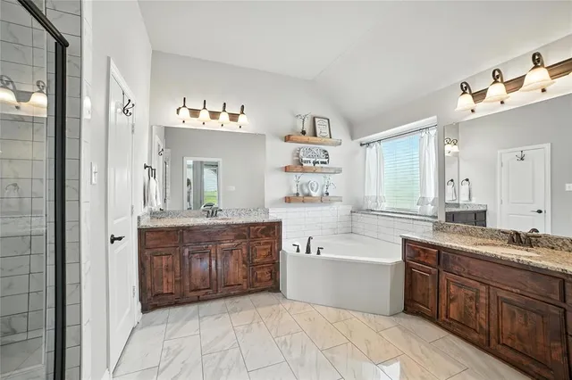 a spacious bathroom with a tub sink and mirror