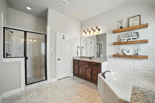 a spacious bathroom with a tub shower and sink