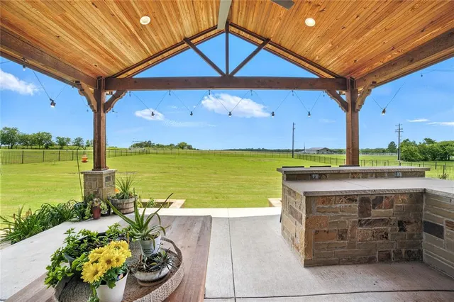a view of a swimming pool with a table and chairs under an umbrella