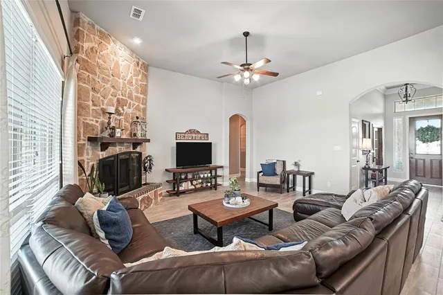 a living room with furniture a flat screen tv and a fireplace