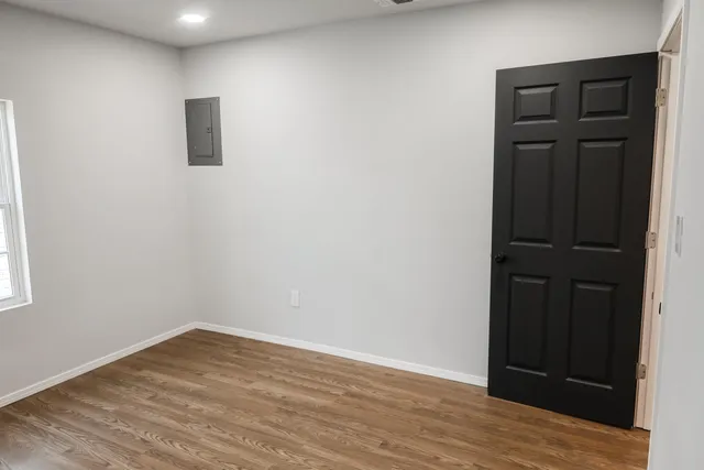 an empty room with wooden floor and closet