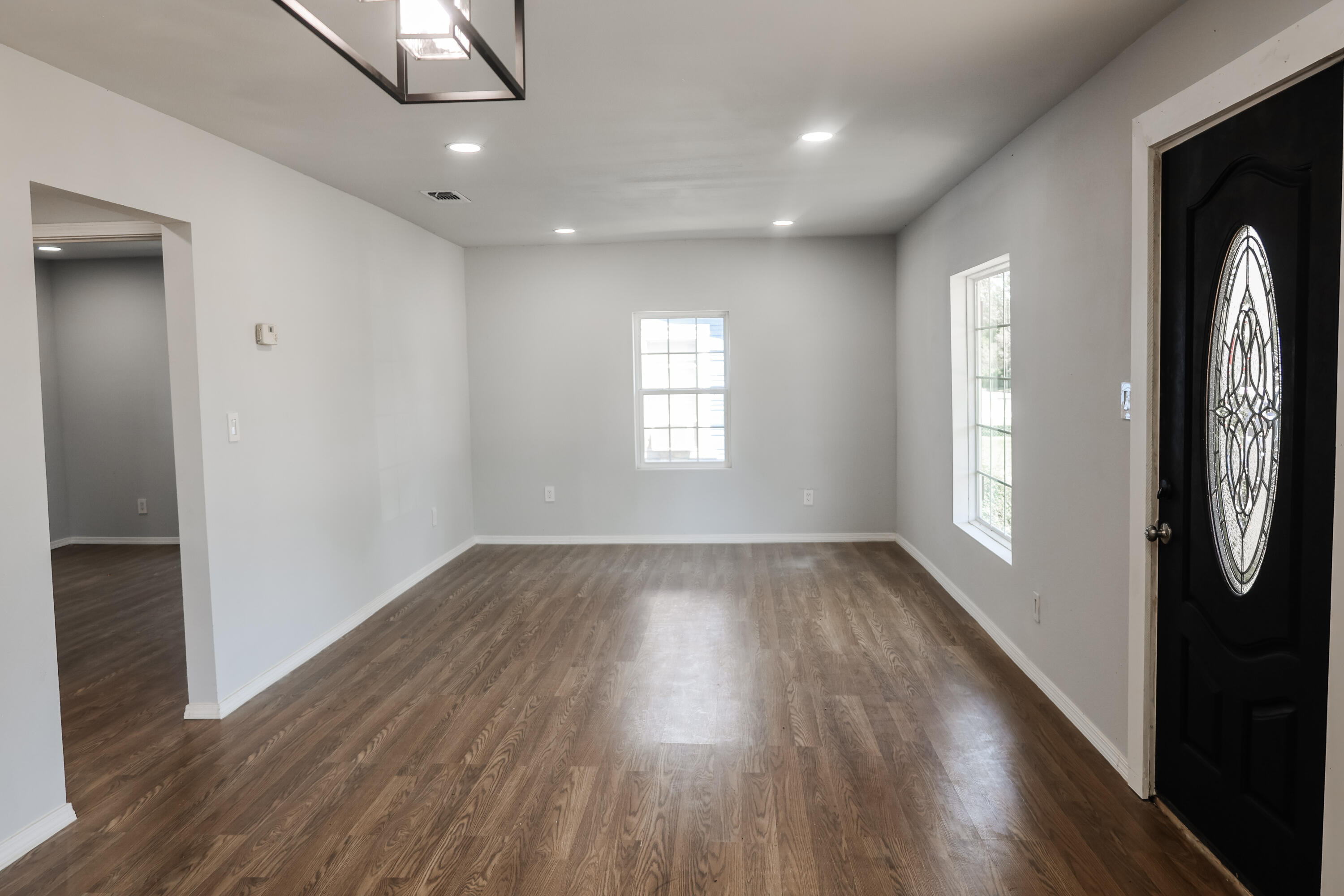 112 Southwest 8th Plainview, TX 79072 - Photo 4 of 24 an empty room with wooden floor and windows