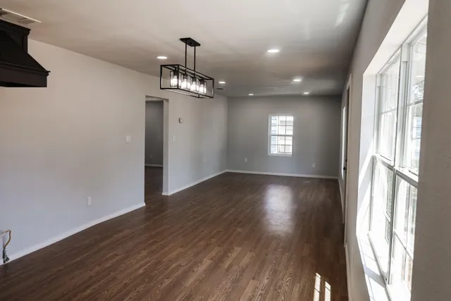 a view of empty room with wooden floor and window