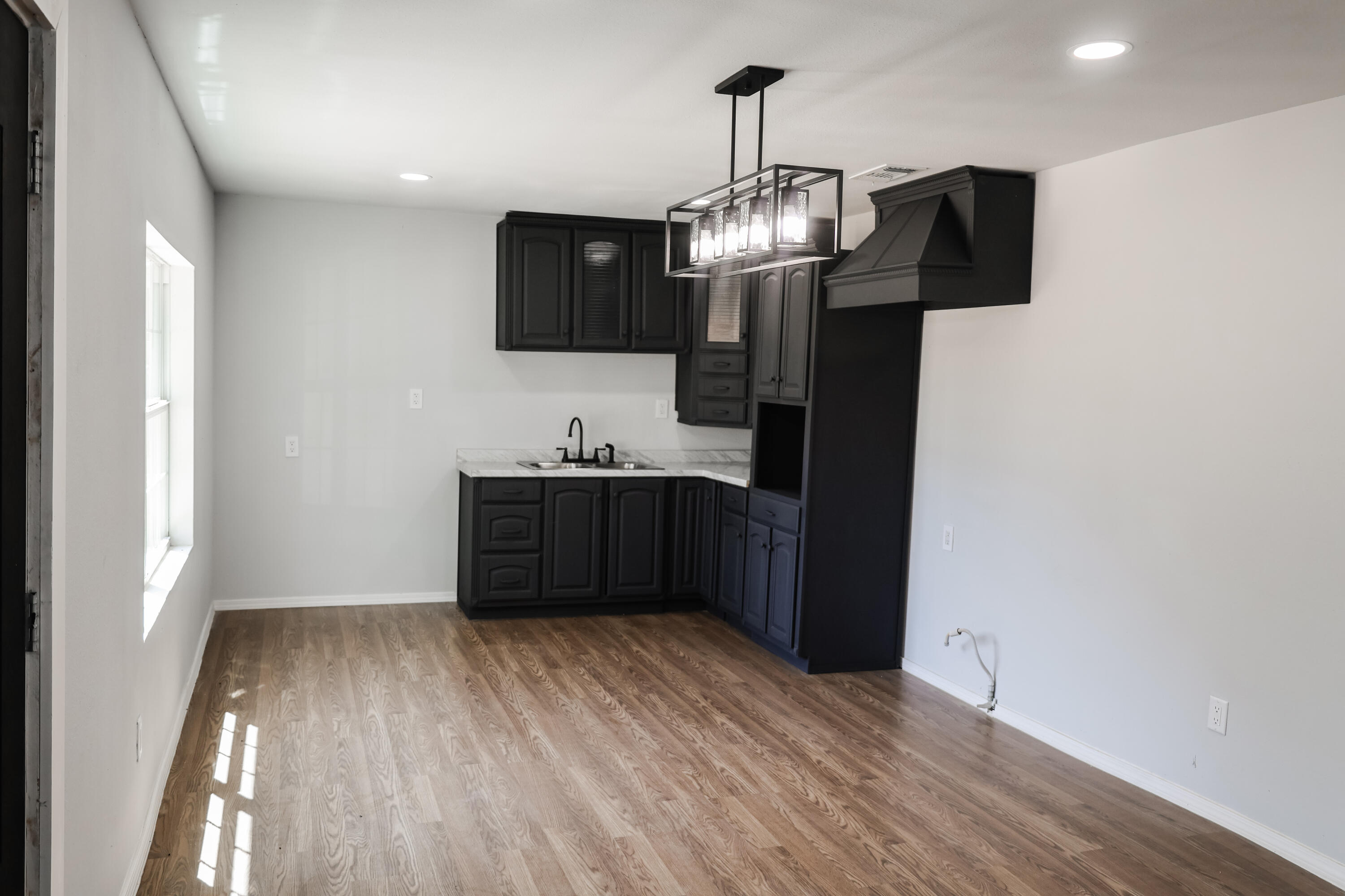112 Southwest 8th Plainview, TX 79072 - Photo 7 of 24 a view of a room with a wooden floor and chandelier