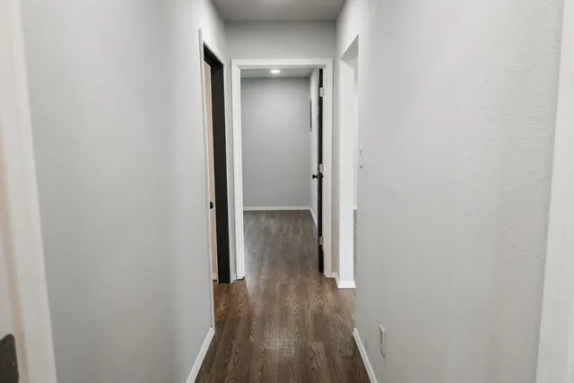 a view of a hallway with wooden floor