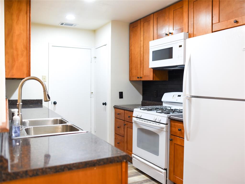 2325 North Ricketts Street Sherman, TX 75092 - Photo 12 of 28 a kitchen with a stove a sink and a refrigerator
