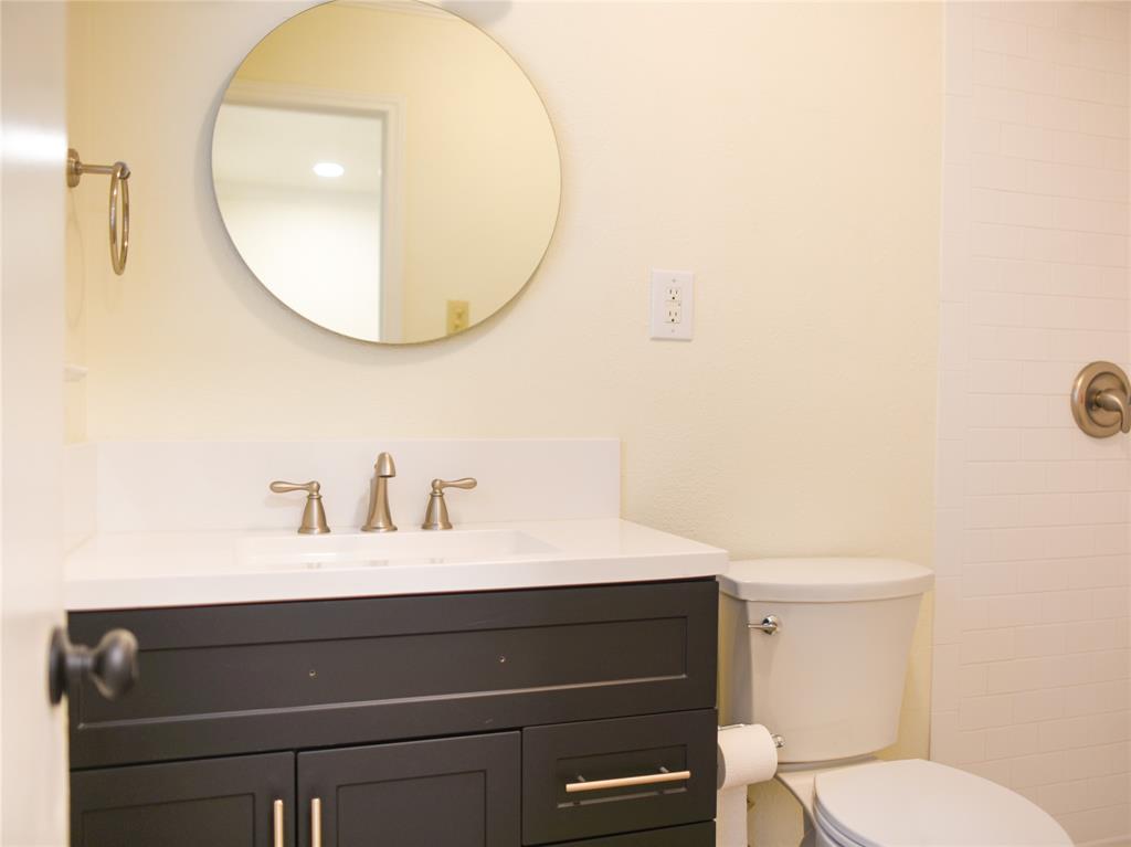 2325 North Ricketts Street Sherman, TX 75092 - Photo 19 of 28 a bathroom with a sink vanity mirror and toilet