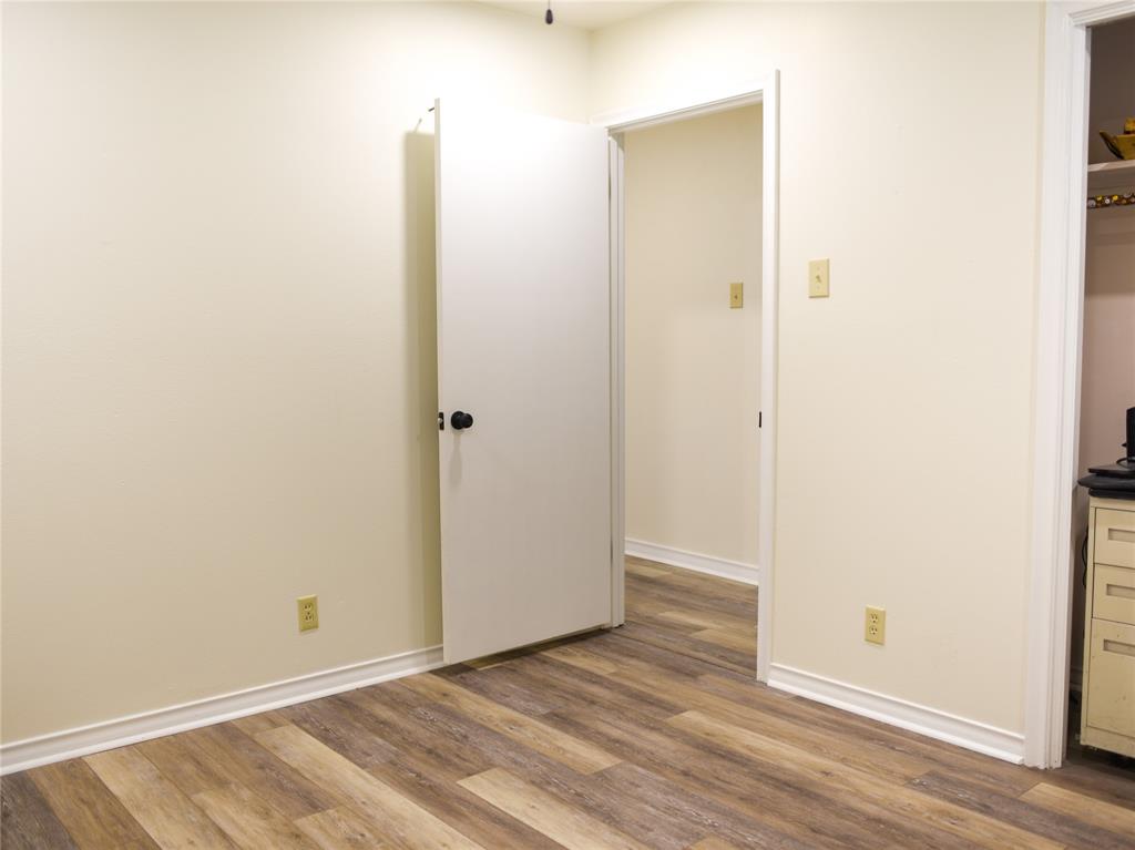 2325 North Ricketts Street Sherman, TX 75092 - Photo 21 of 28 an empty room with wooden floor and a bathroom