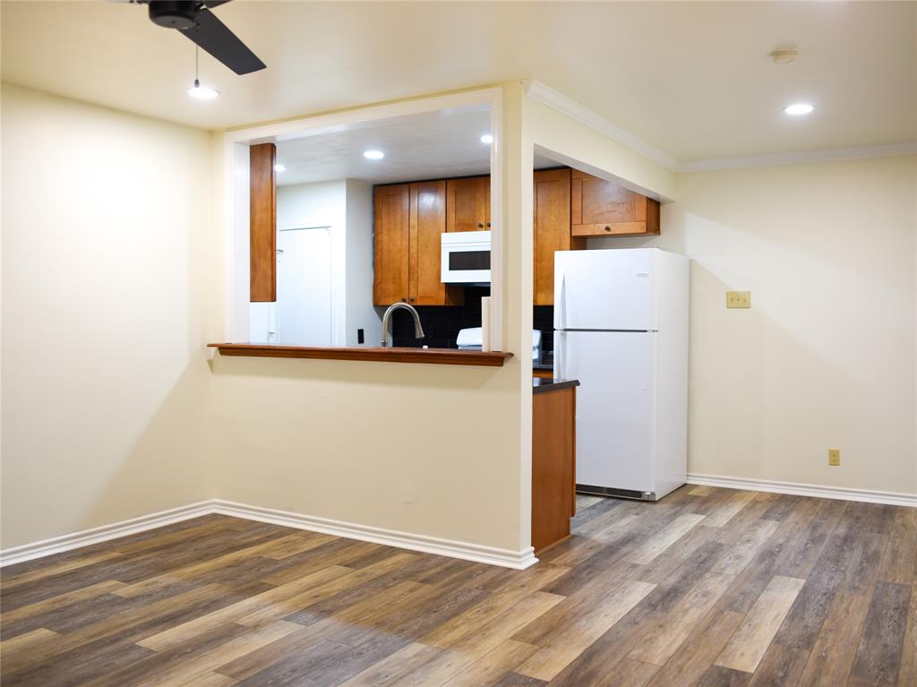 2325 North Ricketts Street Sherman, TX 75092 - Photo 9 of 28 a view of a room with a refrigerator and wooden floor