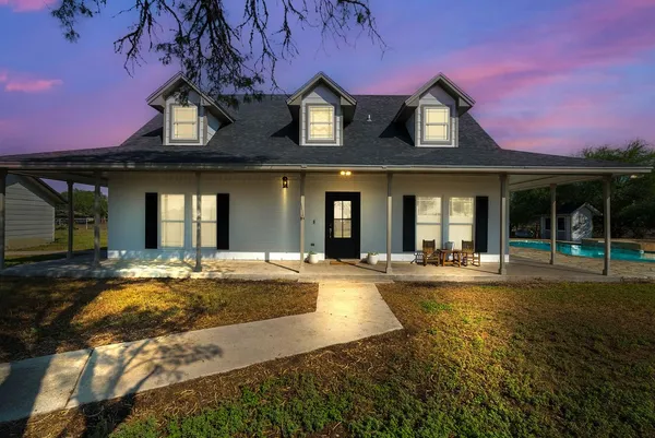 a view of a house with swimming pool and a yard