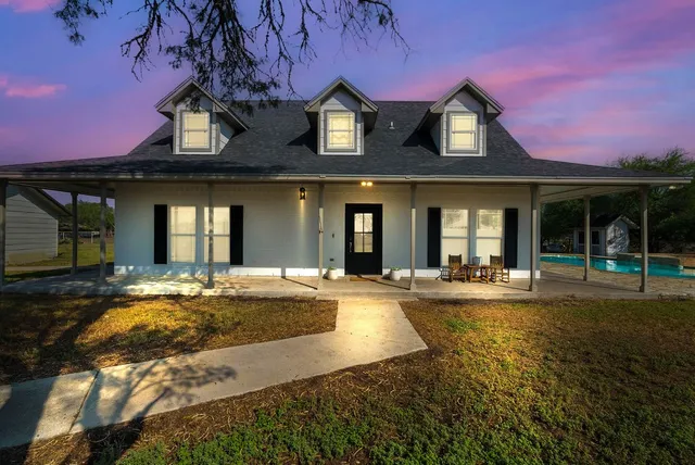 a view of a house with swimming pool and a yard