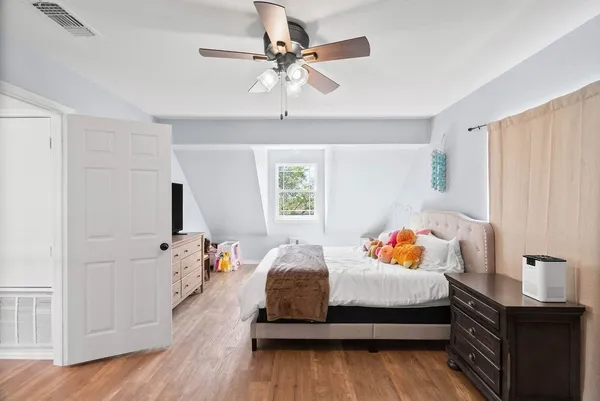 a bedroom with a bed and wooden floor